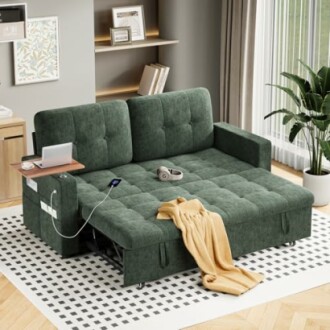 Green sofa bed with a blanket, headphones, and gadgets in a modern living room.