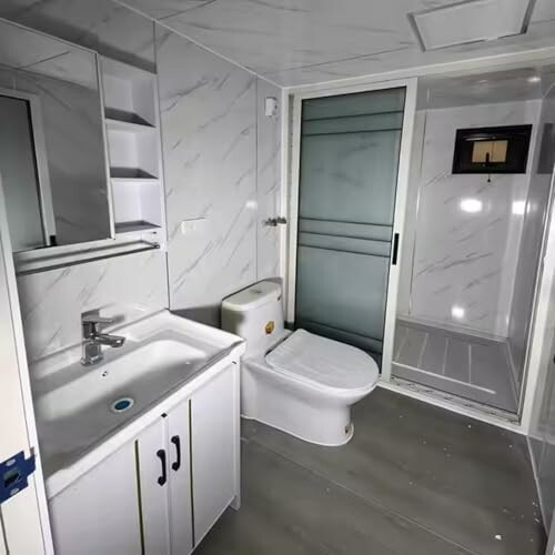 Modern bathroom with sink, toilet, and shower.