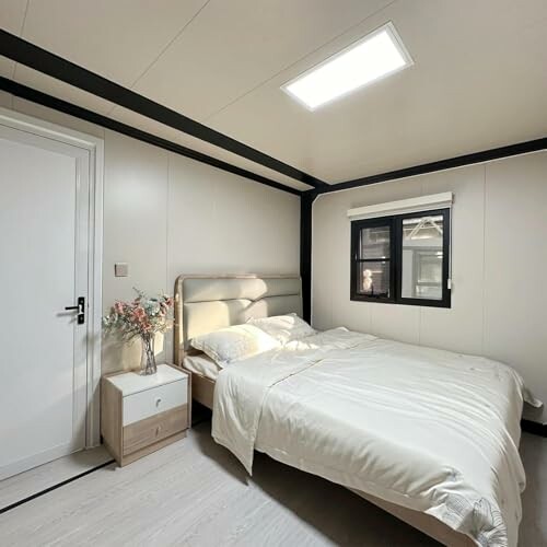 Modern bedroom with bed, nightstand, and window.