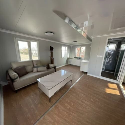Modern living room with sofa, coffee table, and large windows.