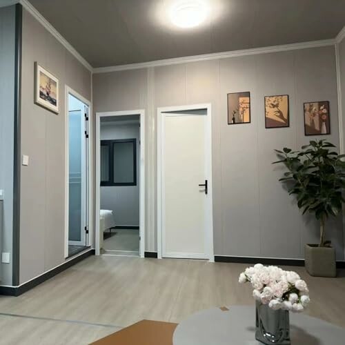 Modern living room with wall art, plants, and doors.