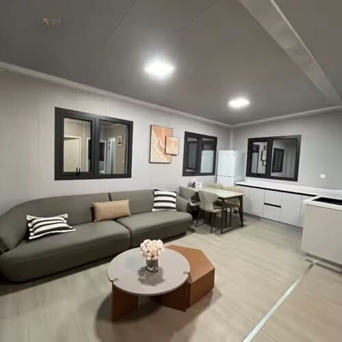 Modern living room with sofa and integrated kitchen area.