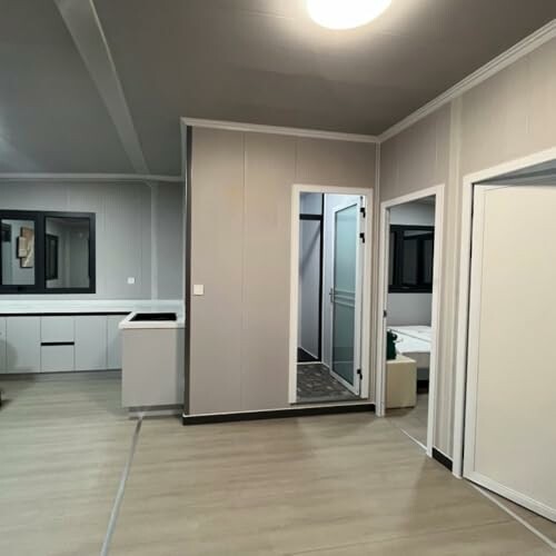 Modern minimalist room with light wood flooring and neutral walls.