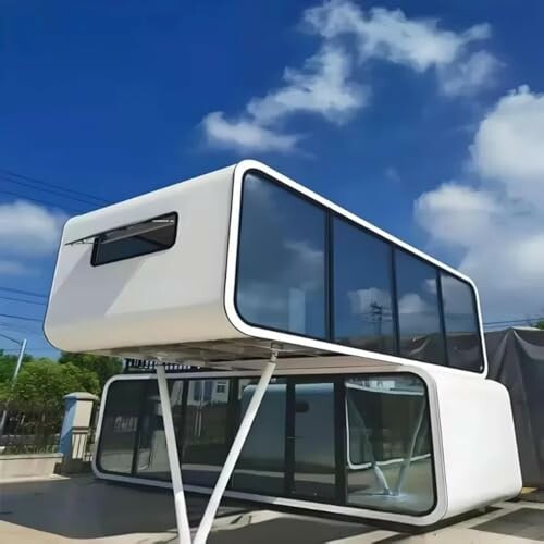 Modern modular home with stacked glass units under blue sky.