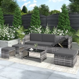 Modern outdoor furniture set with gray cushions and glass-top table on a patio.