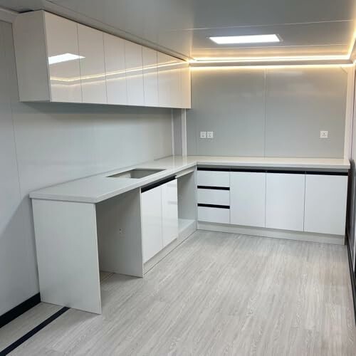 Modern kitchen with white cabinets and under-cabinet lighting.