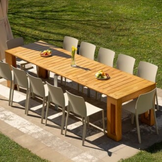 Long wooden dining table with chairs on patio